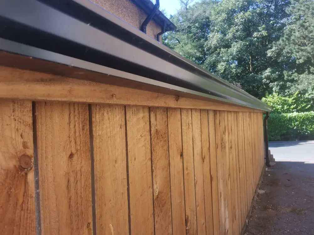 Black guttering fitted to a timber outbuilding