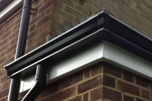 Black guttering and white soffit detail on a brick house